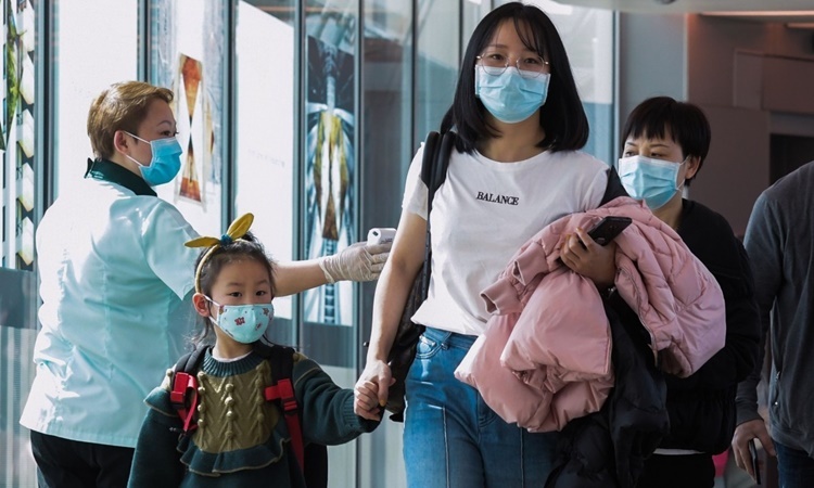 Nhân viên y tế kiểm tra thân nhiệt hành khách tại sân bay quốc tế Changi, Singapore, hồi cuối tháng hai. Ảnh: AFP.
